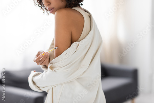Cropped view of african american woman with diabetes doing insulin injection in living room © LIGHTFIELD STUDIOS