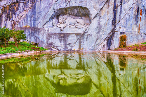 Lion of Lucerne and its reflections in waters of memorial pond, Lucerne, Switzerland photo
