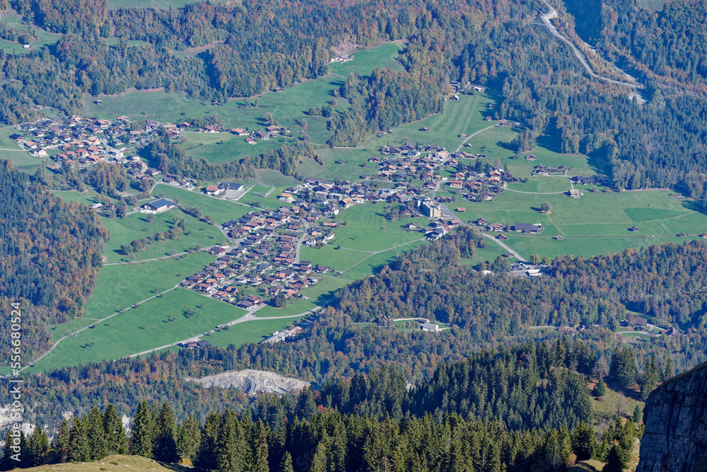 Scenic autumn landscape with aerial view of village Hofstetten in the Swiss Alps at Axalp, Canton Bern, on a sunny autumn morning. Photo taken October 18th, 2022, Axalp, Switzerland.