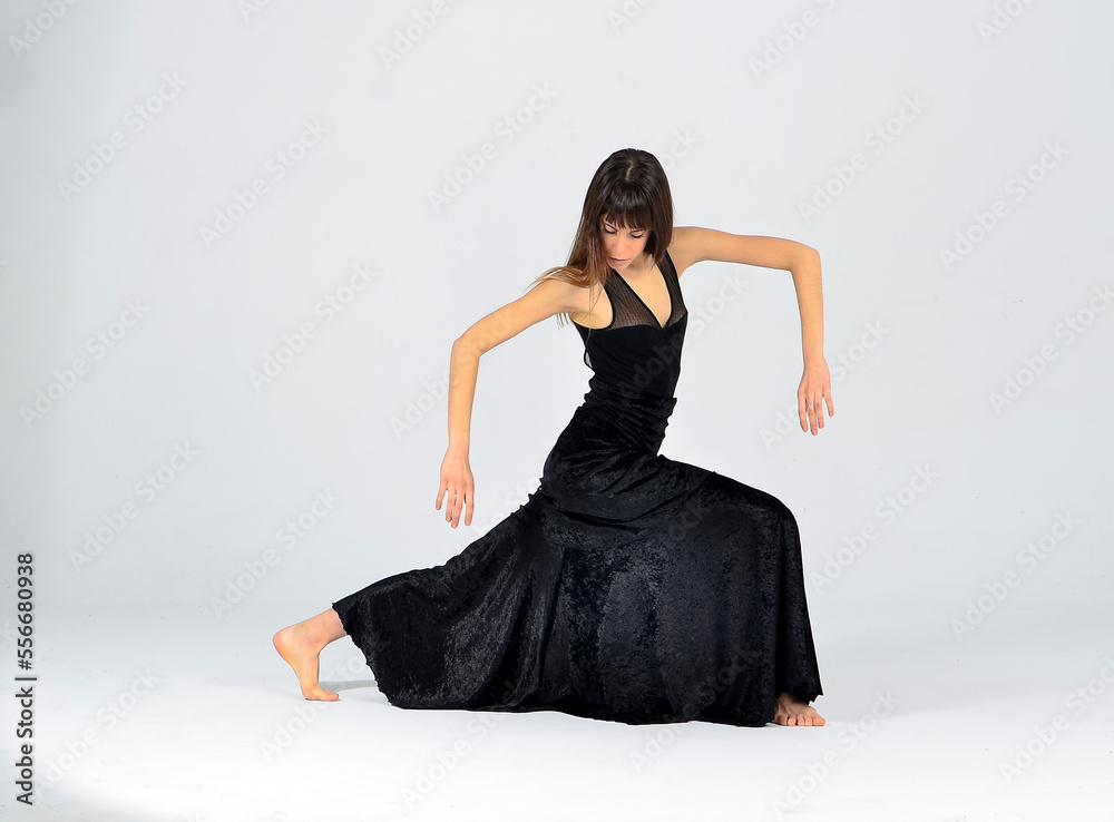 Fototapeta premium Female dancer isolated dancing with black dress on grey background