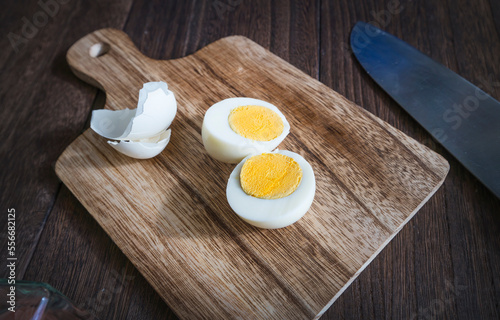 boiled egg peeled and cut in half on a cutting board. 