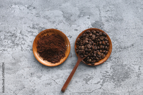 Coffee powder and beans on wooden tray and spoon isolated on gray background. 