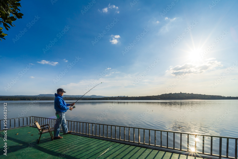 man enjoys catching fish in background nature blue sky, fishery concept