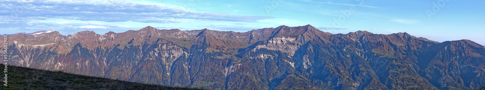 Beautiful wide angle autumn landscape at Bernese Oberland with Bernese Alps, Lake Brienz and mount Brienzer Rothorn on a blue cloudy autumn morning. Photo taken October 18th, 2022, Axalp, Switzerland.