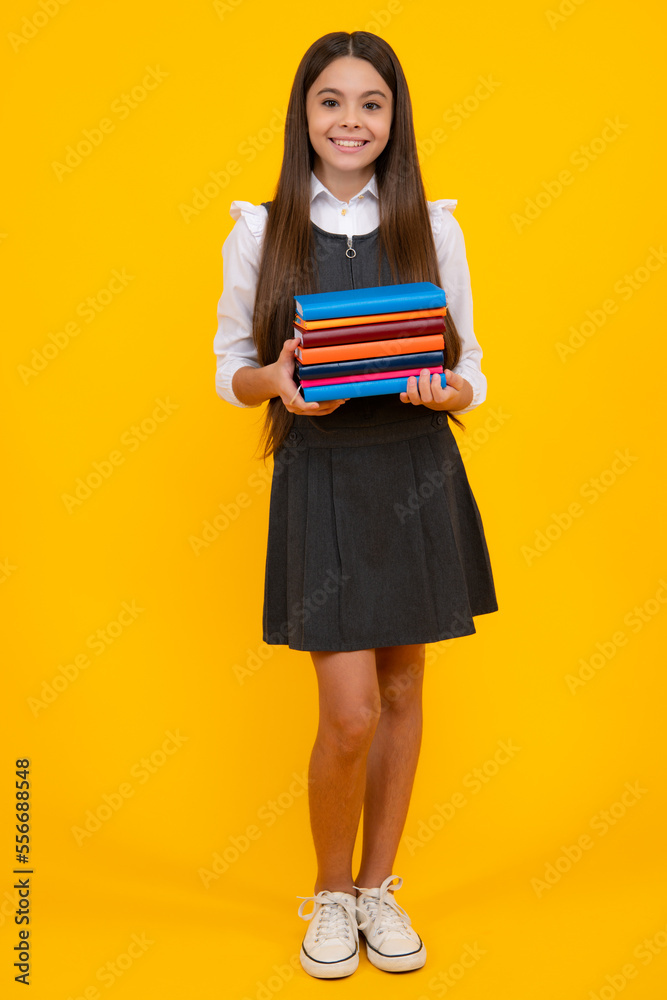 Back to school. Teenager schoolgirl with book ready to learn. School girl children on isolated yellow studio background. Back to school. Teenager schoolgirl with book ready to learn. School girl children on isolated yellow studio background.