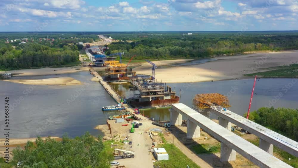 Aerial shot passing over a bridge construction project at sunset in Vistula near Warsaw.  Construction of the Most Polnocny bridge. Poland
