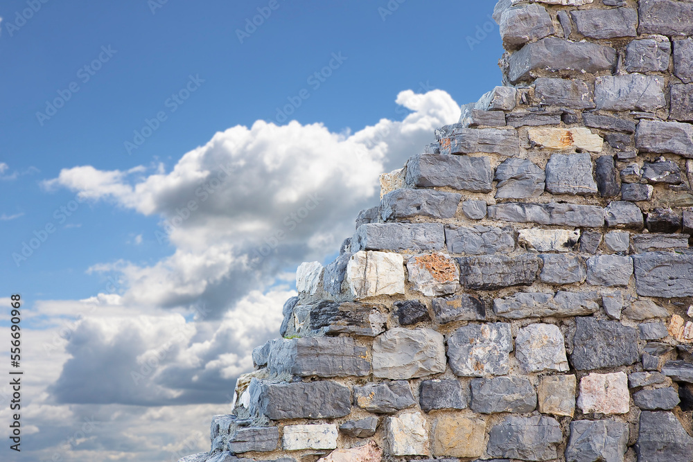 Stone wall with large stone blocks against a sky background - concept image with copy space