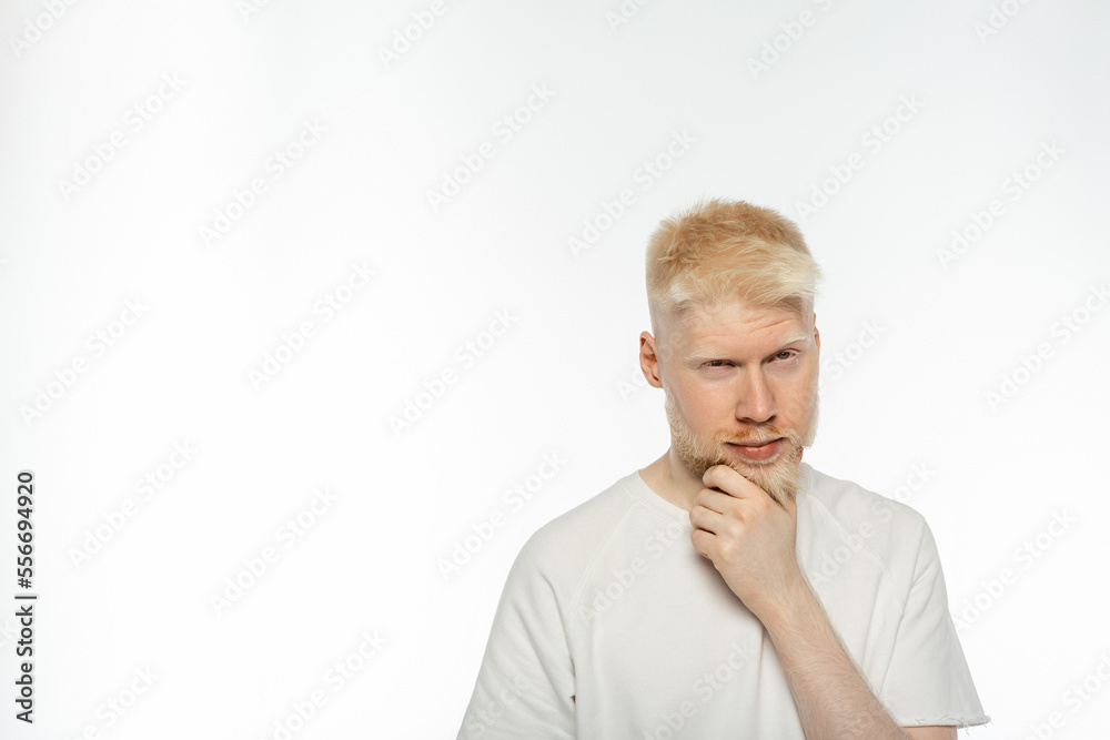puzzled albino man in t-shirt touching beard while thinking on white background puzzled albino man in t-shirt touching beard while thinking on white background