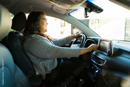 Smiling obese woman listening the radio on the car
