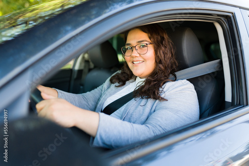 Happy fat latin woman driving her car and smiling