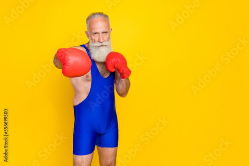 Full length photo old age pensioner wear red boxing gloves versus hit serious grandfather professional empty space ad new gym isolated on yellow color background