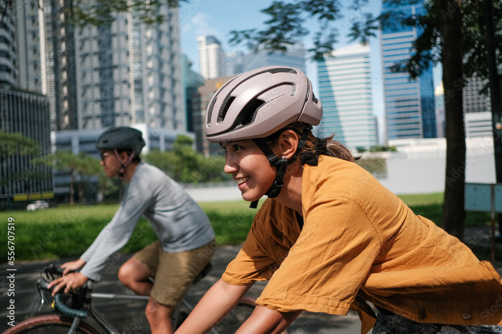 © Jonathan De Guzman - A young couple riding their bikes together in the city.