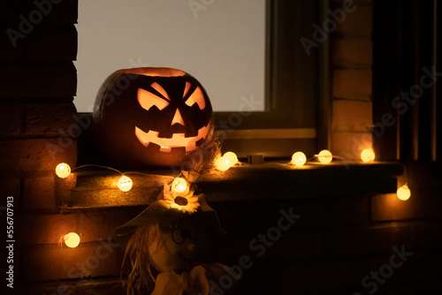 Obraz na płótnie Spooky Halloween pumpkin, Jack O Lantern with pumpkins lights hanging from a win