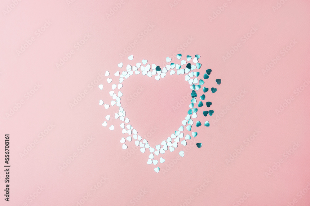 Heart made from silver confetti on pink background. Valentines day holiday concept. Mockup