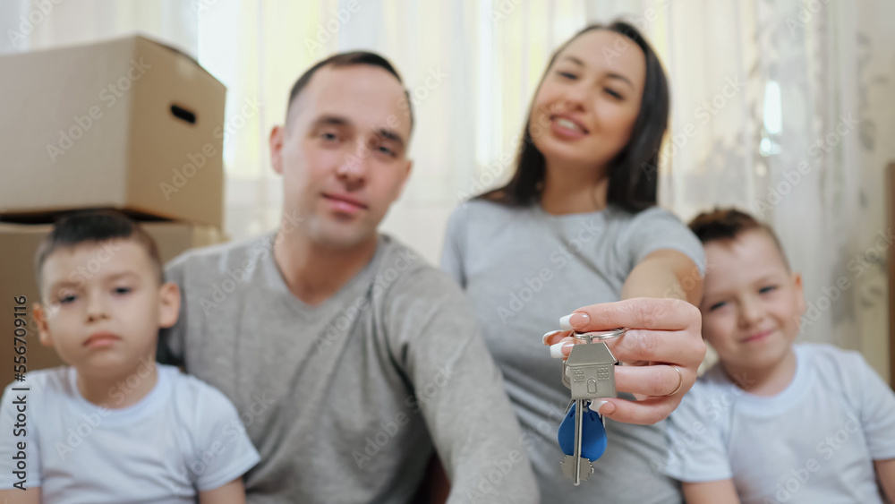 Amused family enjoys moving together into new apartment and holds key. Excited parents and boy children get ready for arrangement in own property, selective focus Amused family enjoys moving together into new apartment and holds key. Excited parents and boy children get ready for arrangement in own property, selective focus