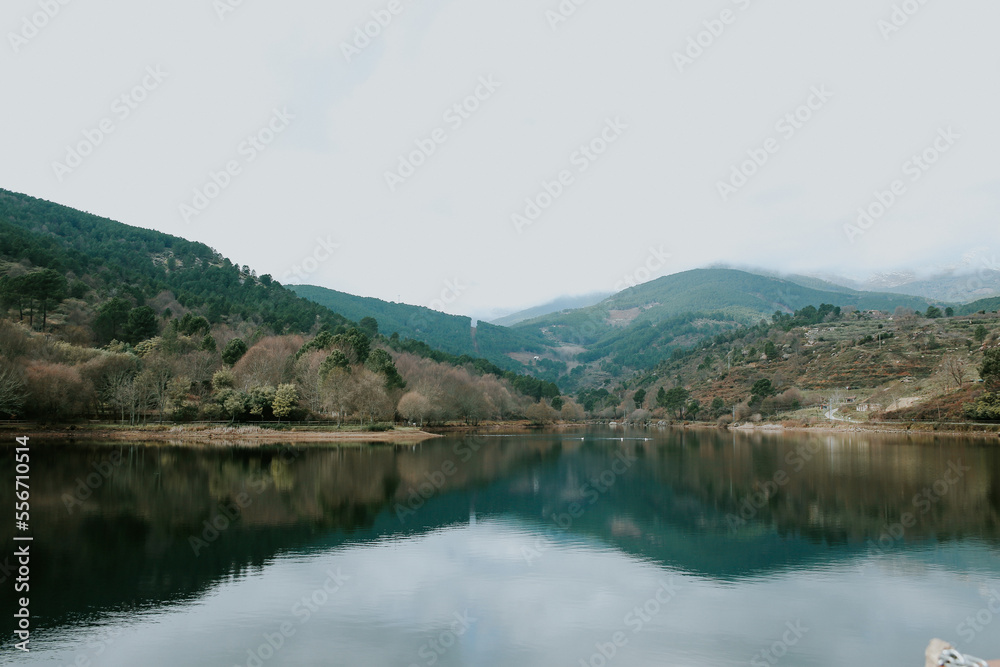 Pantano en la sierra de Ávila, España con montañas y nieve.