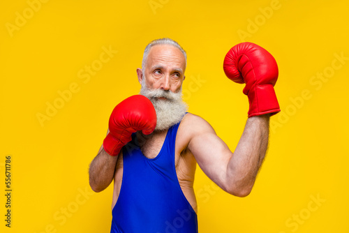 Photo of focused concentrated person wear boxing gloves punch isolated on yellow color background