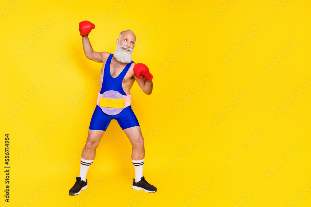 Full size photo of handsome sportive person wear boxing gloves soft fluffy belt look empty space isolated on yellow color background