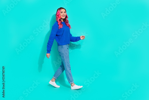 Full body size cadre of young walking stylish trendy casual outfit autumn comfort look attractive lady dyed hair isolated on cyan color background