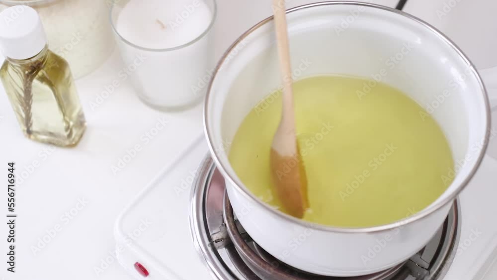 Creative occupation of candle making melting soy wax in the jar and stirring it Creative occupation of candle making melting soy wax in the jar and stirring it