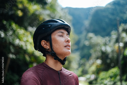 A young female cyclist is practising a breathing exercise.
