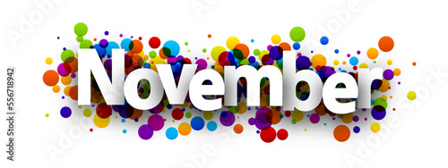 November word over colorful round dots confetti background.