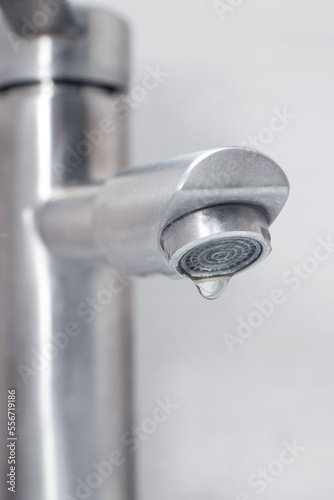 Water dripping from the faucet in the bathroom. Water faucet close-up. Saving water