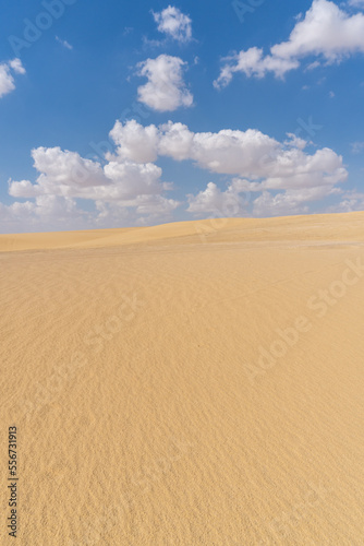 Image of the Sahara desert in Egypt, with yellow sand, and dunes, on a sunny day with clouds