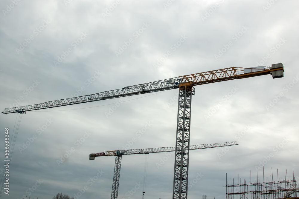 Cranes on the construction site against the blue sky Cranes on the construction site against the blue sky