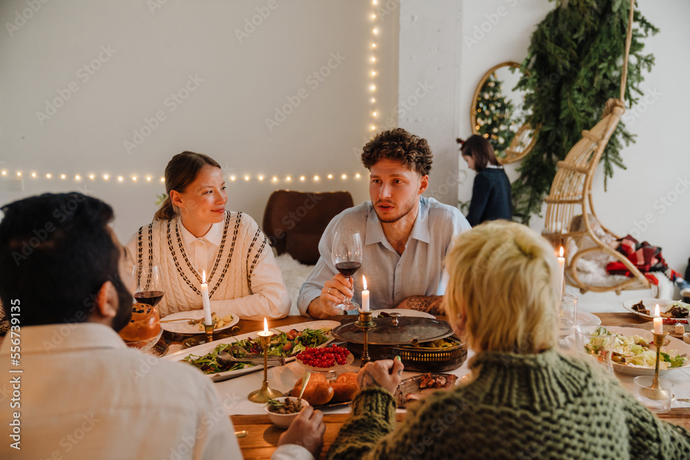 Cheerful family having Christmas dinner while sitting in cozy room