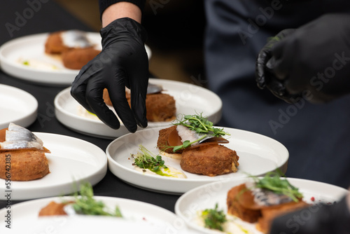 Fototapeta Naklejka Na Ścianę i Meble -  chief serving herring with potato Kroket croquette Dutchs favourite snack deep-fried ragout filled snack coated with breadcrumbs