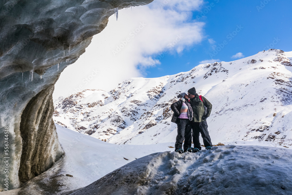A married couple kisses in the entrance of a Castner Glacier ice cave
