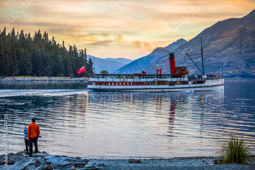Tourists watching the famous TSS Earnslaw takes a sunset tour around Queenstown's Lake Wakatipu; Otago, New Zealand photo
