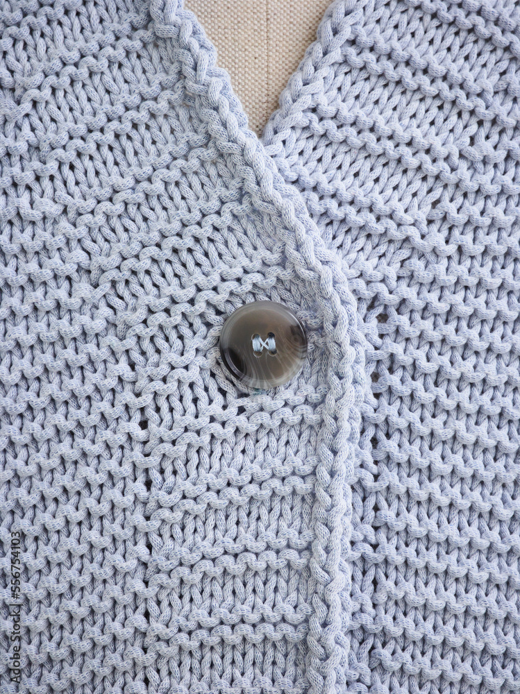 Extreme close-up of the collar and button on a grey knit sweater on a mannequin; Studio Extreme close-up of the collar and button on a grey knit sweater on a mannequin; Studio