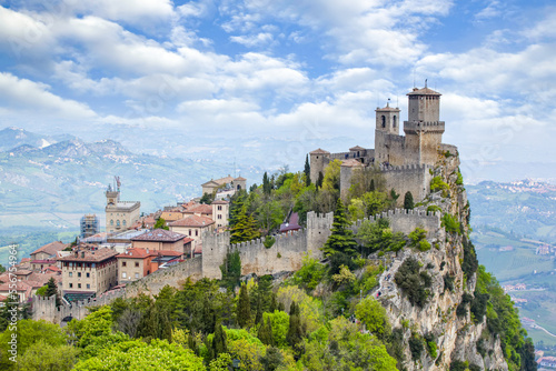 Guaita Tower on the peak of Mount Titan with a cloud filled sky on a sunny day;  Republic of San Marino, North-Central Italy photo