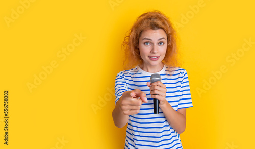 music concept. woman singer isolated on yellow background. woman singer point finger.