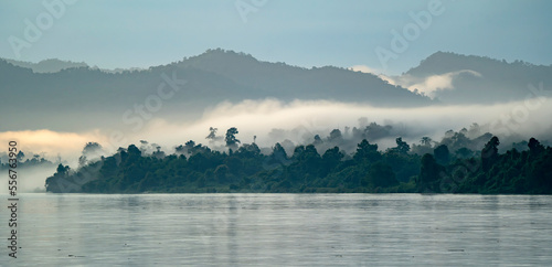 Dawn morning mist rising over the jungle covered banks of the Ayeyarwady (Irrawaddy) River at dawn; Rural Jungle, Kachin, Myanmar (Burma) photo