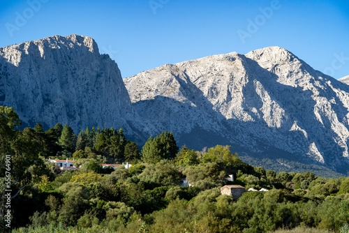 Sunlit mountains and forest with villa near Su Gologone; Sardinia, Italy photo