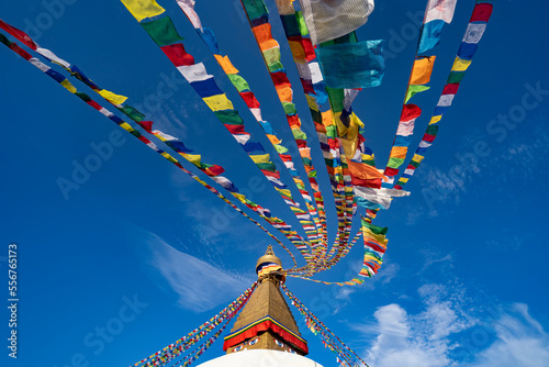 Colorful prayer flags hanging from the golden spire of the largest Tibetan Buddhist stupa in Nepal at Boudhanath superb of Kathmandu; Kathmandu, Kathmandu, Nepal photo