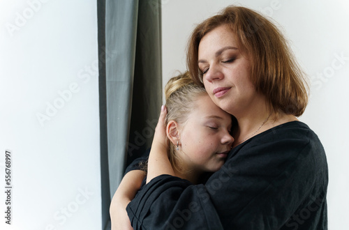 Mom hugs her teenage daughter, presses her to her chest.