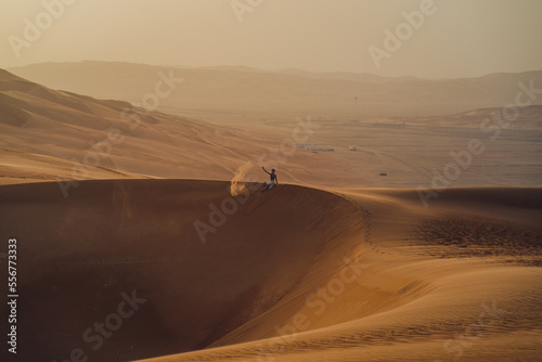 Fototapeta Naklejka Na Ścianę i Meble -  Person sitting on the Moreeb Dunes at Rub Al Khali in the UAE