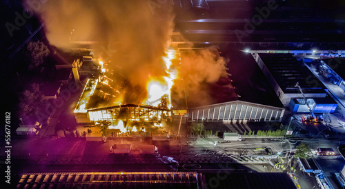 Fotografiet Big fire of an industrial company in the night taken by a drone
