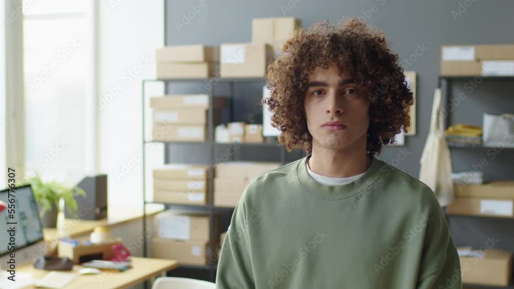 Portrait waist up shot of young man posing for camera while working in delivery service office Portrait waist up shot of young man posing for camera while working in delivery service office
