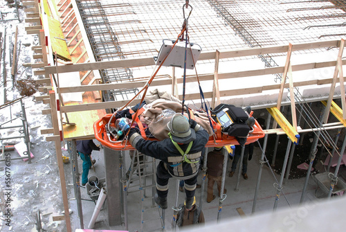 Rescue operations of a worker inside a construction site. A firefighter recovers an injured person with the ladder and stretcher