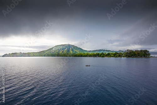 People in a canoe in front of the jungles of Dobu Island, D'Entrecasteaux Islands, Papua New Guinea photo