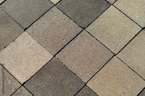Cement tiles laid in diamond shapes  with a rough texture.