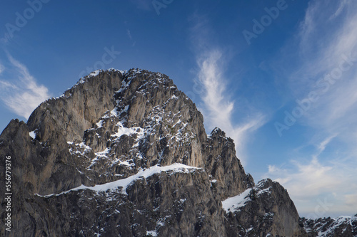 Gran montaña nevada bajo un cielo azul con pocas nubes en invierno