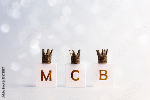 Happy Three King's Day. Three letters M, C, B with crowns on light background. Letters M, C, B means three Kings name Melchior, Caspar, Balthazar.