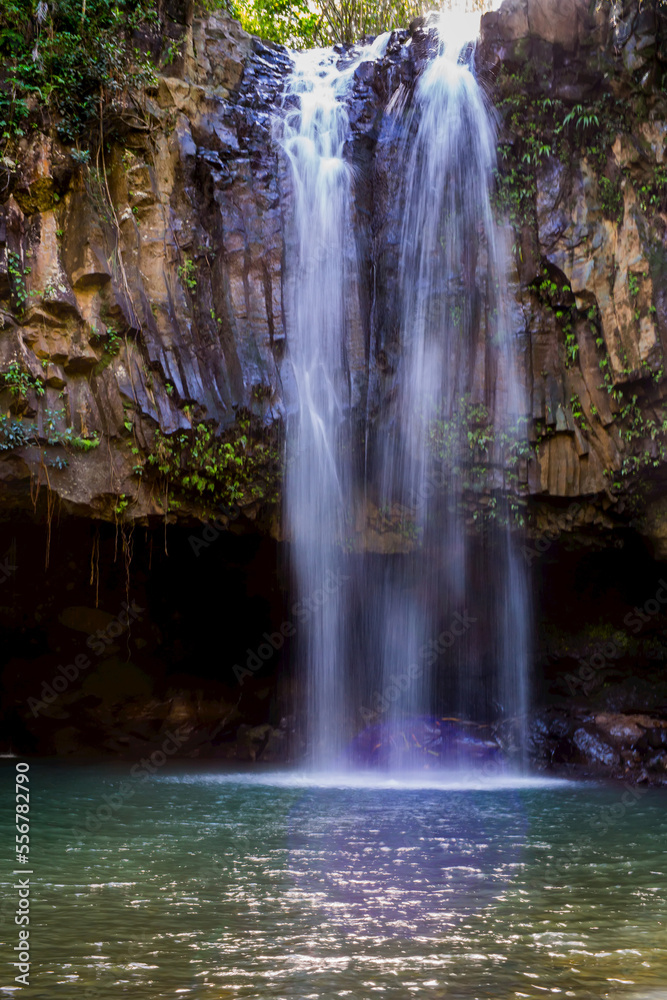 A waterfall cascades over volcanic rock in Hawaii. A waterfall cascades over volcanic rock in Hawaii.