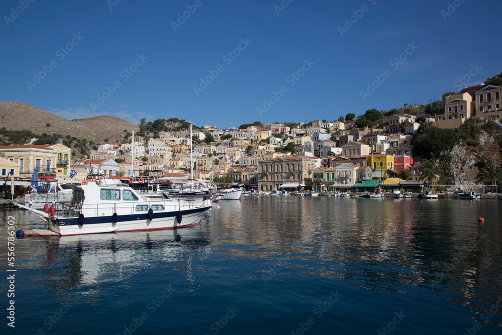 Cabin Cruisers and sailboats moored in the marina at Gialos Harbor, Symi (Simi) Island; Dodecanese Island Group, Greece Cabin Cruisers and sailboats moored in the marina at Gialos Harbor, Symi (Simi) Island; Dodecanese Island Group, Greece